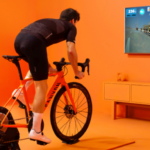 Man doet aan zwift race in oranje kamer